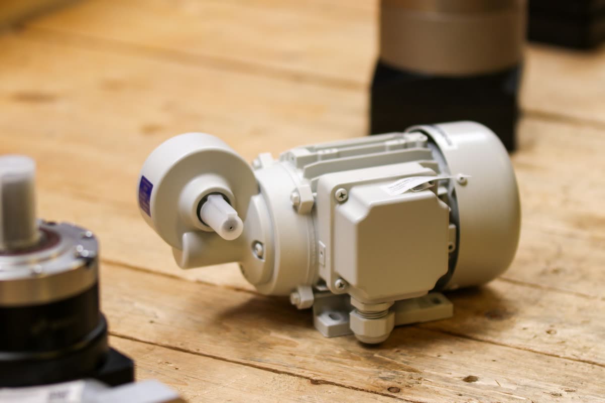 Electric motor coupled to a gearbox standing on a workbench